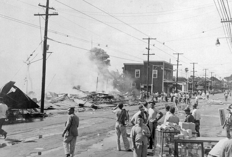 Civilians standing among debris along a street in Honolulu, Hawaii