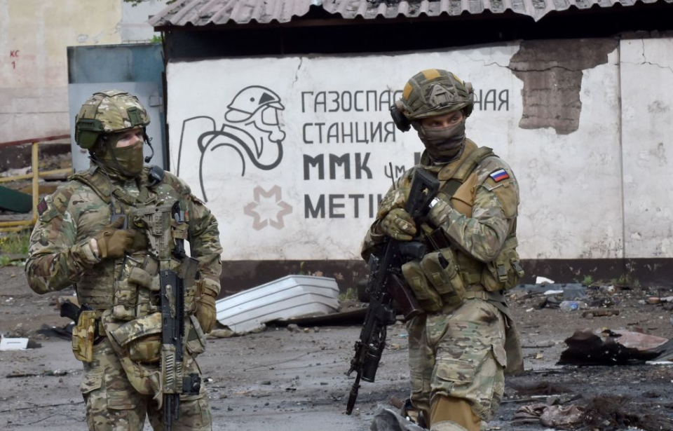 Two Russian soldiers standing in front of a wall covered in graffiti