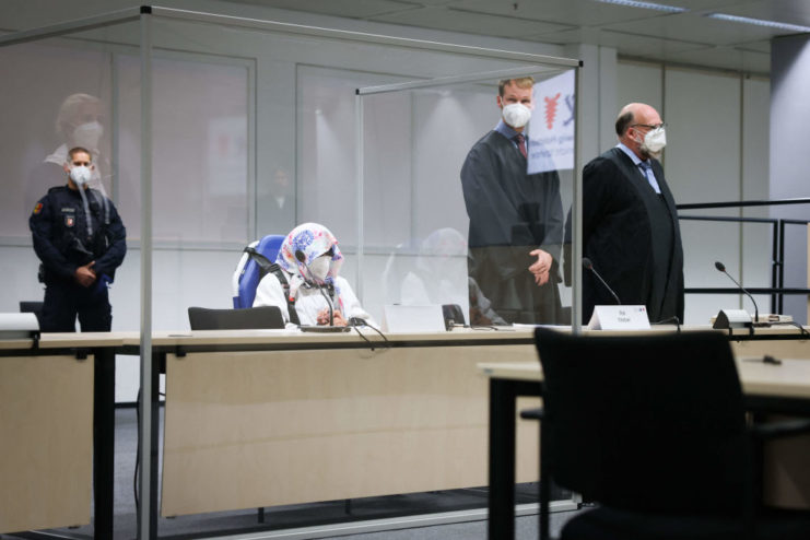 Irmgard Furchner sitting with her face covered in court