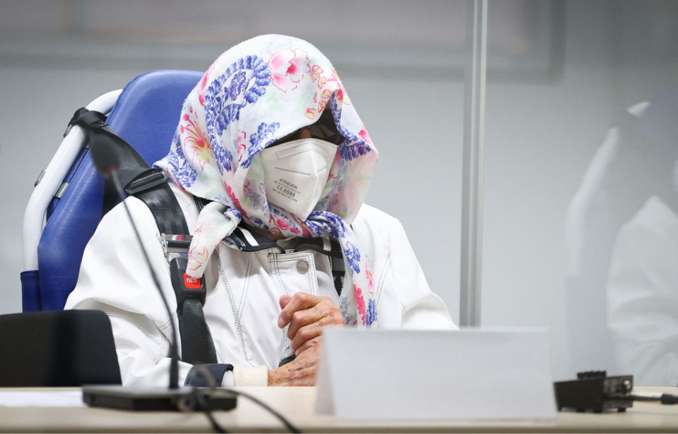 Irmgard Furchner sitting with her face covered