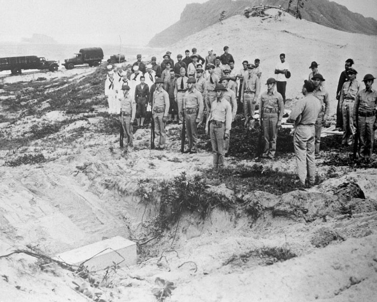 US military personnel standing beside the grave of a Japanese pilot killed during the attack on Pearl Harbor