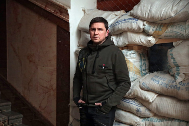 Mykhailo Podolyak leaning against sandbags