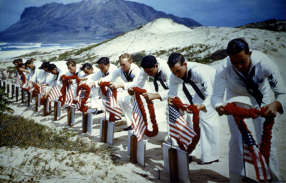 US Navy sailors placing leis on the graves of fallen servicemen