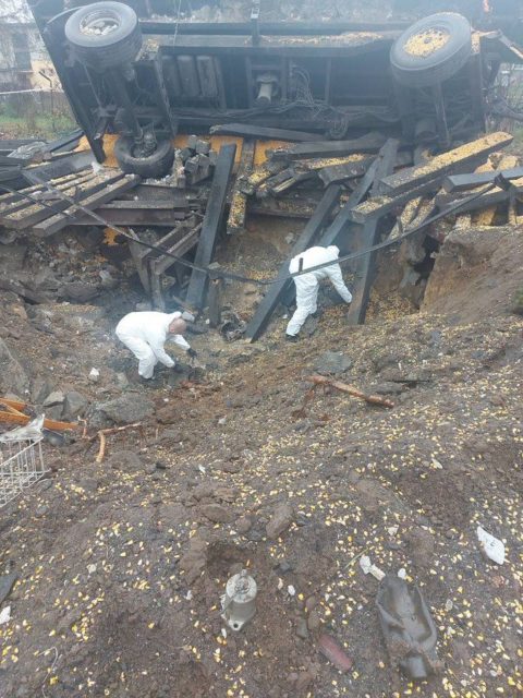 Two Polish police officers standing in a missile crater