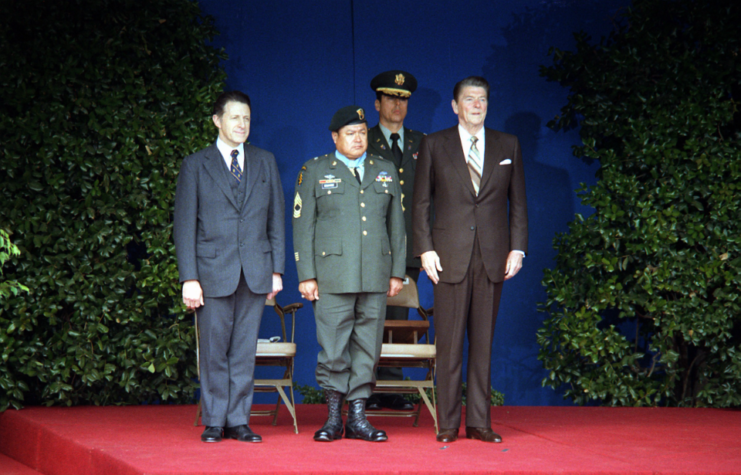 Roy Benavidez, Ronald Reagan and two other men standing together on stage