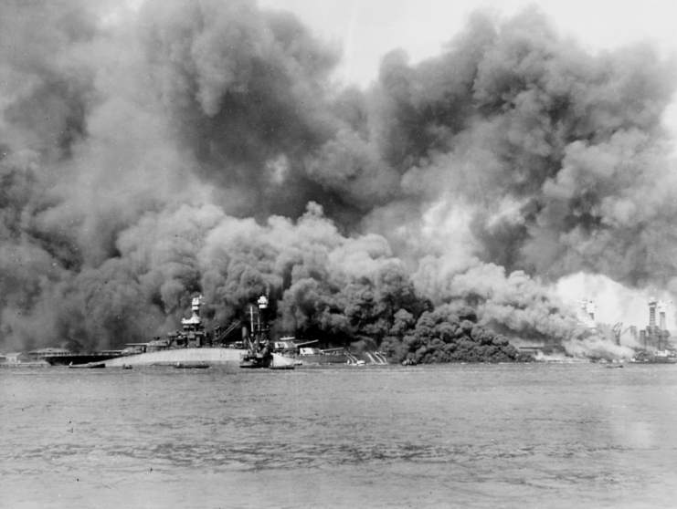 Capsized USS Oklahoma (BB-37) shrouded in smoke