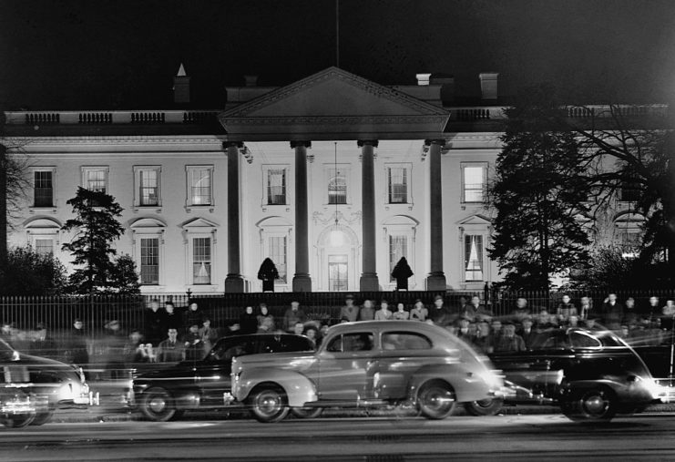 Car driving past a crowd gathered outside of the White House