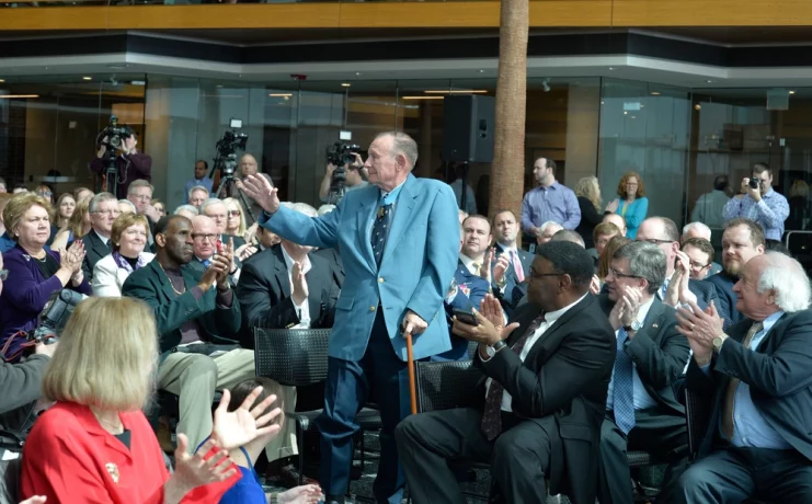 Robert Simanek waving to a crowd applauding him