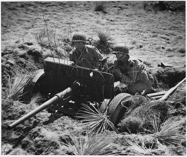 Two US military personnel manning a 37 mm gun M3