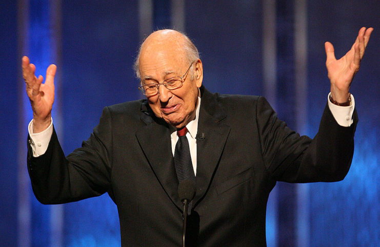 Carl Reiner speaking at a microphone on stage