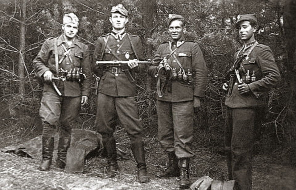 Henryk Wybranowski, Edward Taraszkiewicz, Mieczysław Małecki and Stanisław Pakuła standing together in a wooded area