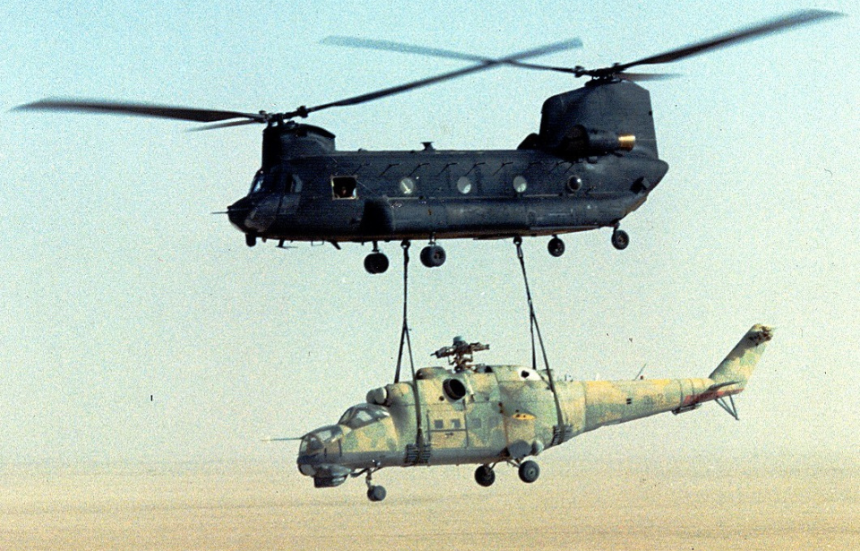 Boeing MH-47 Chinook carrying a Mil Mi-25 Hind D over the desert