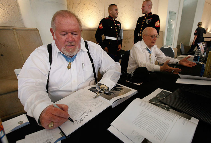 Gary Wetzel and Hershel Williams signing books at a table