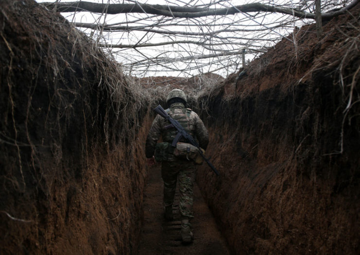 Ukrainian soldier walking through a trench