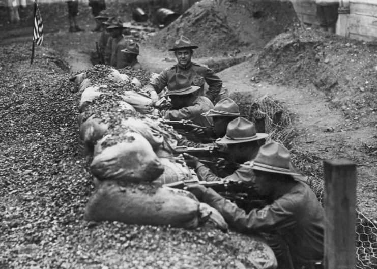 Men with the 15th New York Regiment aiming rifles from a trench