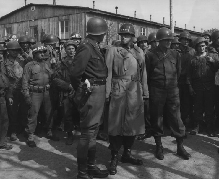 George Patton, Omar Bradley and Troy Middleton standing among a group of US military officials at Ohrdruf concentration camp