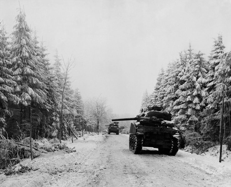 Two M4 Sherman tanks driving along a snow-covered road