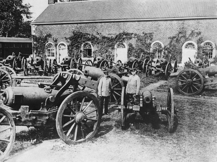 German soldiers standing with captured Belgian artillery weapons following the Battle of Liège