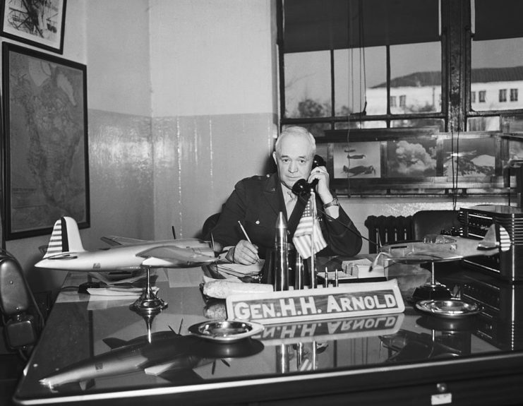 Henry H. Arnold talking on a telephone while sitting at his desk