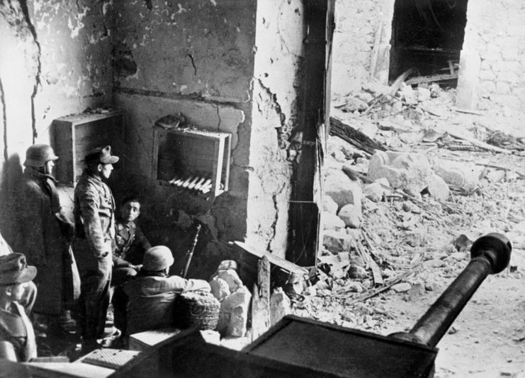 German paratroopers sitting in the ruins of a house