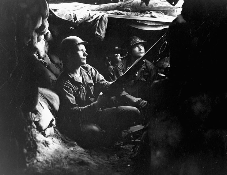 Three US infantrymen sitting in a tunnel