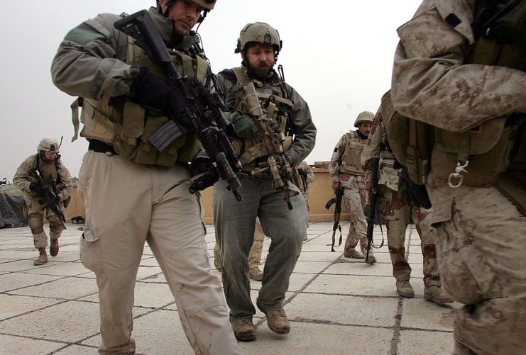 Group of US Navy SEALs and Marines standing atop the roof of an observation post