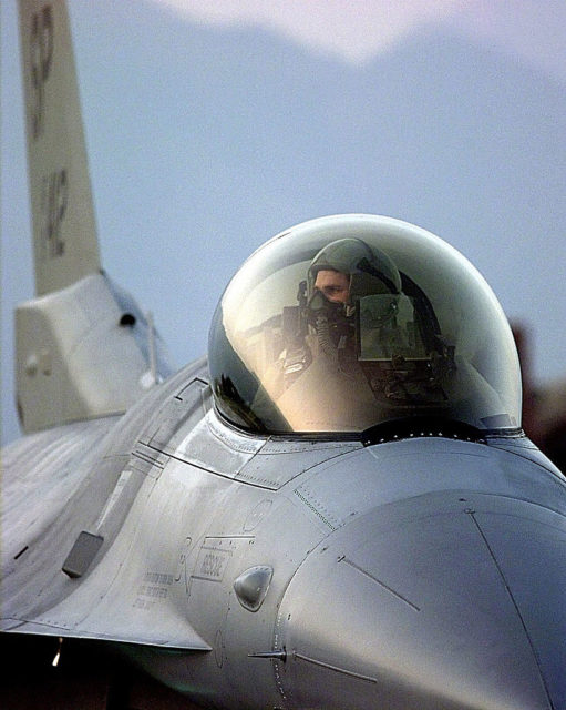 Pilot sitting in the cockpit of a General Dynamics F-16 Fighting Falcon