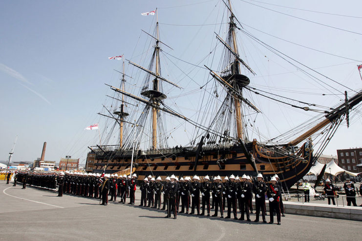 British Royal Navy sailors standing along the side of the HMS Victory