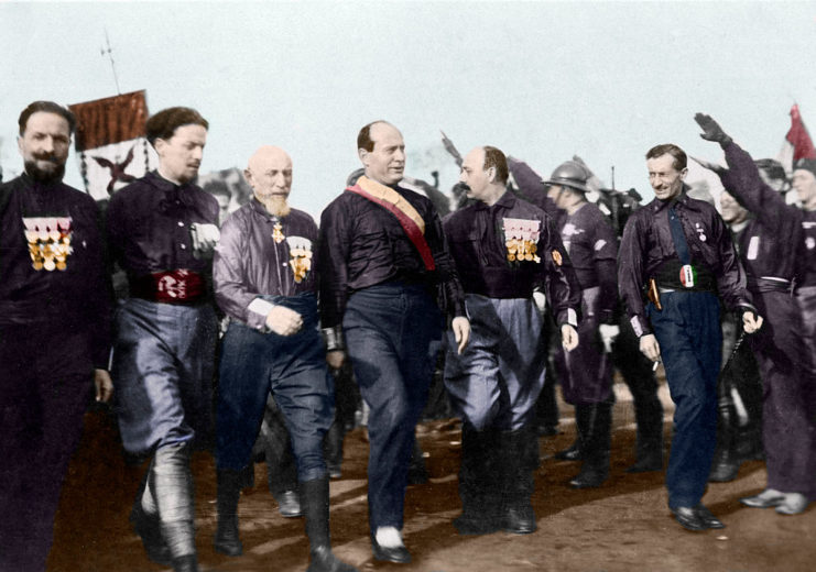Benito Mussolini walking with a group of Fascist leaders