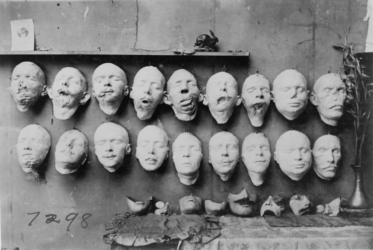 Two rows of facial masks on display on a concrete wall