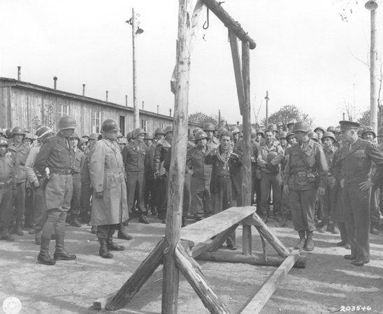 Dwight D. Eisenhower, George Patton and other US military officials standing around the gallows at Ohrdruf concentration camp