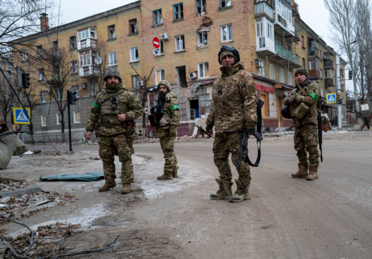 Four Ukrainian soldiers standing in the middle of a street