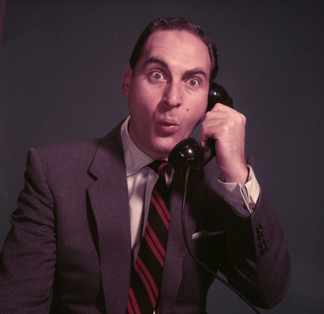 Sid Caesar holding a telephone up to his ear