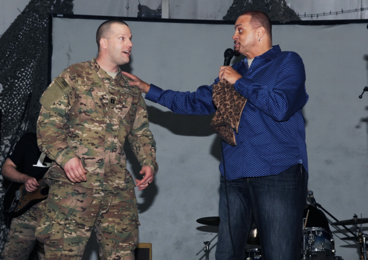 Capt. Todd Brackett standing on stage with Sinbad