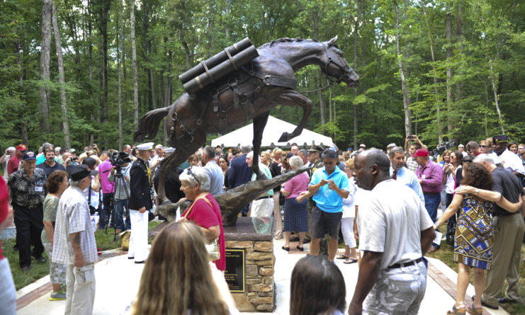 Crowd gathered around a bronze statue of Sergeant Reckless