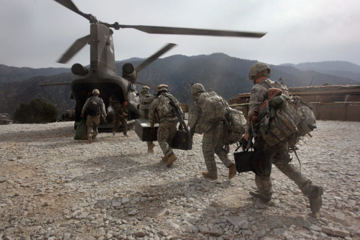 Line of soldiers running toward a Chinook helicopter