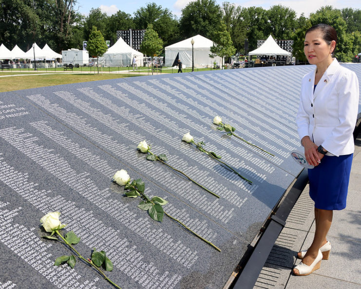 Yumi Hogan standing in front of the Wall of Remembrance at the Korean War Veterans Memorial