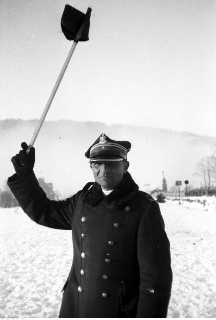 Henryk Dobrzański waving a flag in the snow