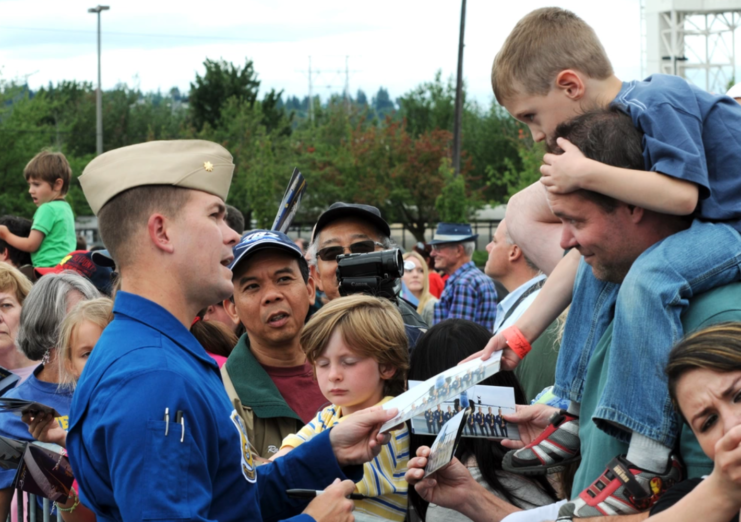 Frank Weisser handing back an autographed photo to a child