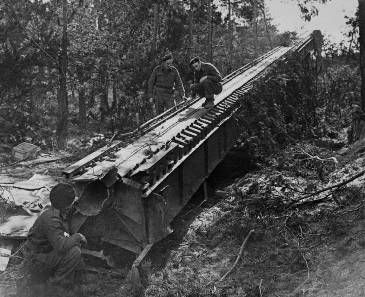 Three Allied soldiers inspecting the launch ramp for a V-1 "buzz bomb"