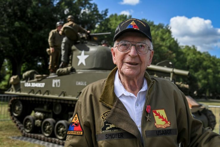Clarence Smoyer standing in front of an M4A3E8 Sherman