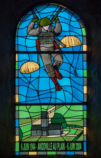 Stained glass window depicting a paratrooper with the 101st Airborne Division parachuting from the sky