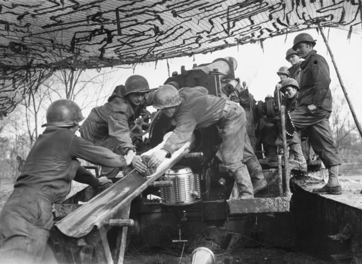 Heavy artillerymen with the US Seventh Army loading a shell into the breach of a 240 mm howitzer M1