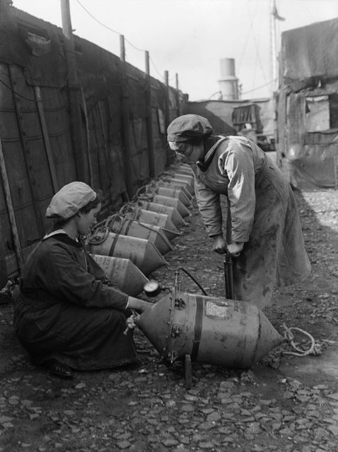 Two women examining an Electric Contact (EC) mine