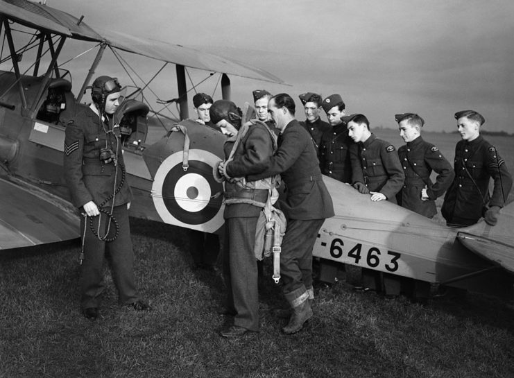 Royal Air Force (RAF) cadets watching instruction on how to fit a parachute