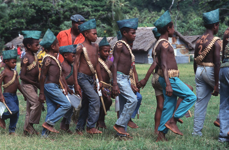 Melanesian boys marching together while wearing faux military outfits