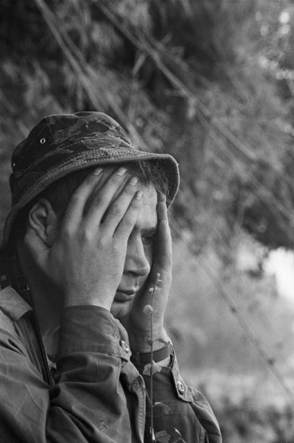 Soldier sitting with his hands over his face