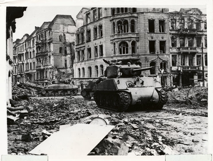 Tanks driving down a debris-strewn street in Cologne