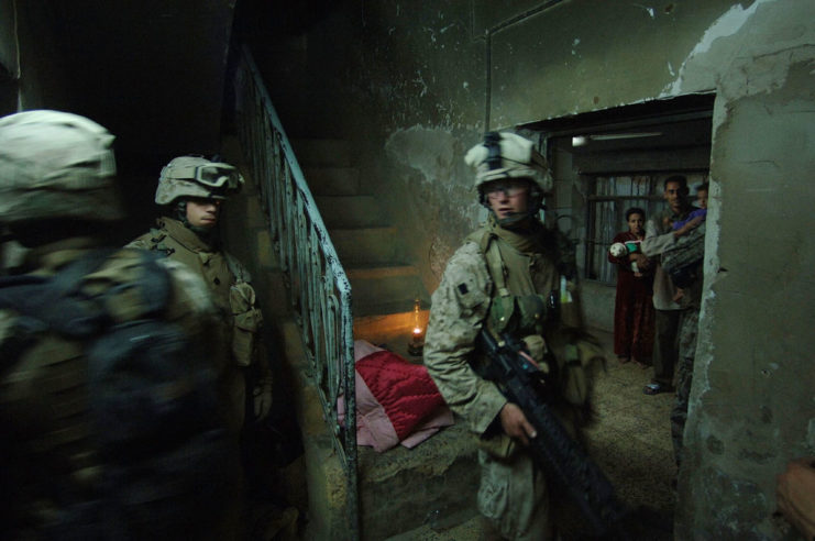 US Marines standing with an Iraqi family inside their home