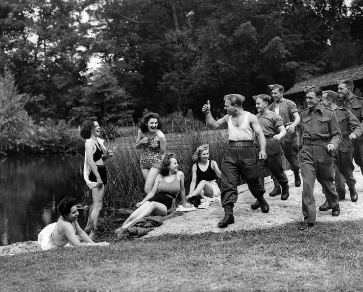 American soldiers walking past a group of women in bathing suits